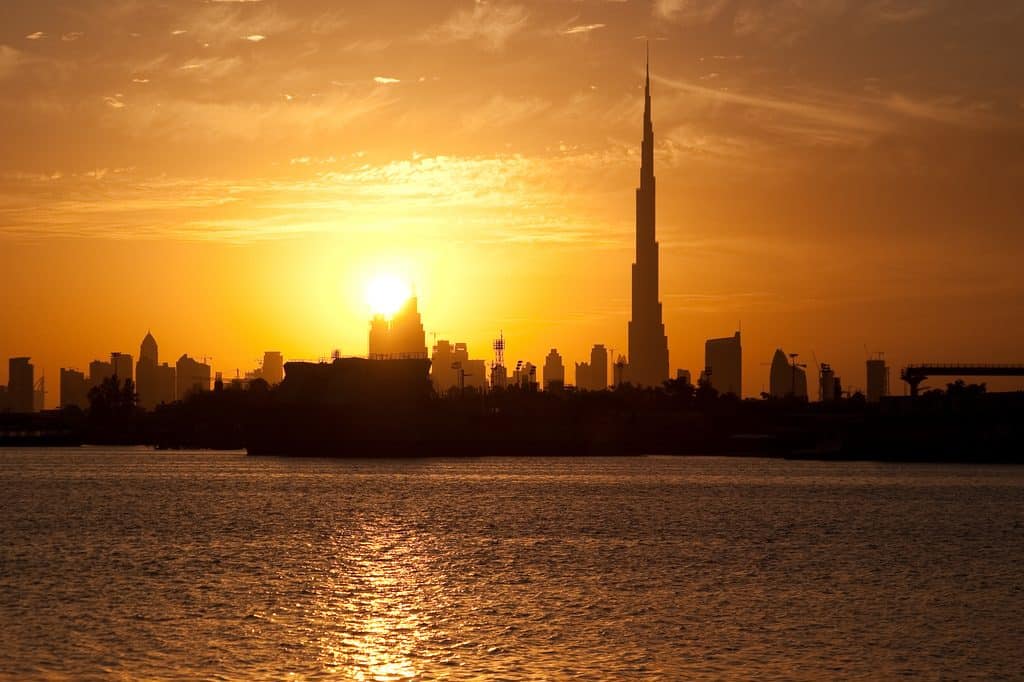 The Dubai skyline at golden hour with beautiful golden hues shimmering off the water and buildings