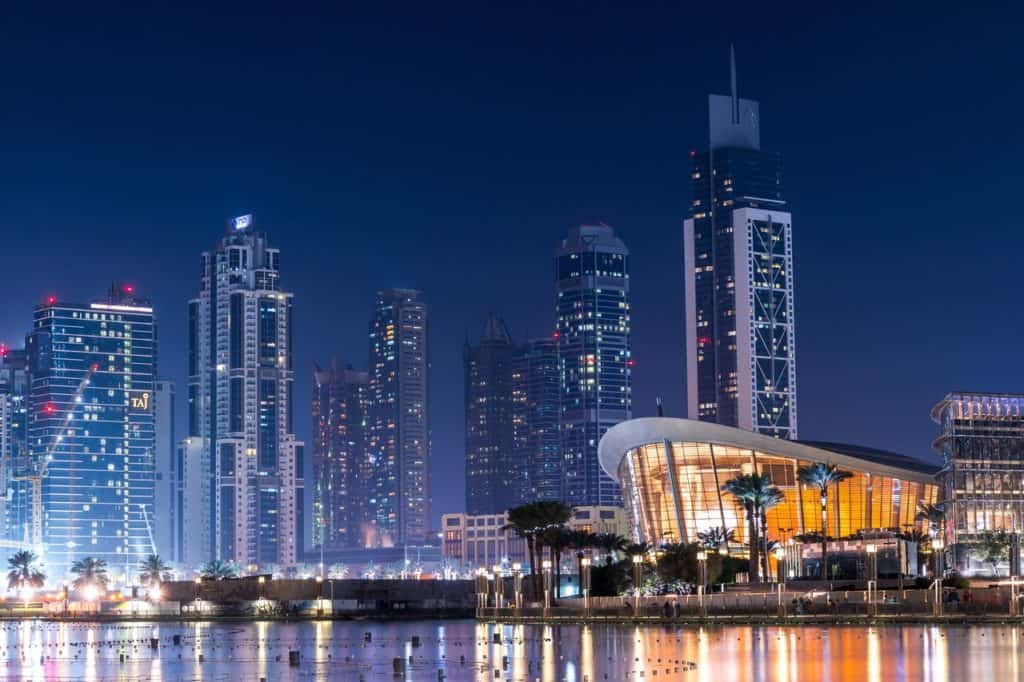 View of Dubai Opera lit up at night from Dubai Fountain and Burj Lake