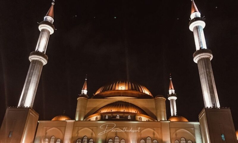 Rahji Mosque in Hail Saudi lit up at night, it's four minarets towering above and large domed roof in the middle