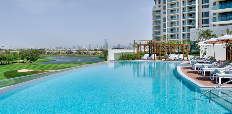 Swimming pool and sun loungers and amazing golf course view at Vida Hotel Emirates Hills in Dubai