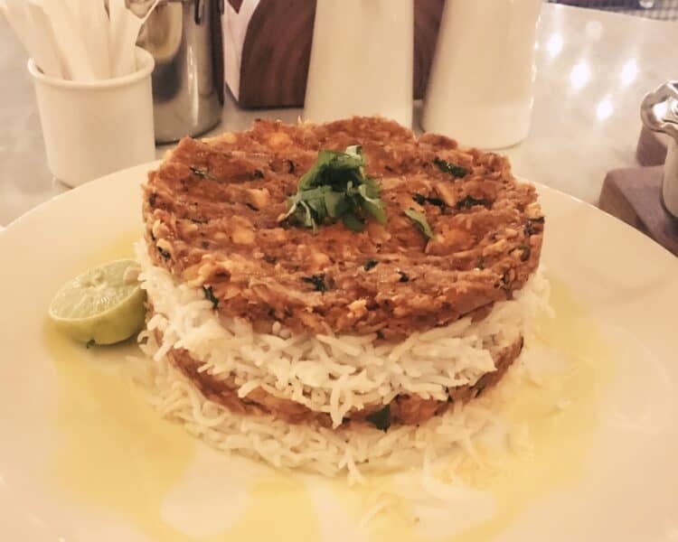 Layers of shark meat and rice placed on top of each other with half a lemon for the Emirati dish Jasheed