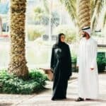 Emirati man and woman walking in the UAE wearing traditional clothes