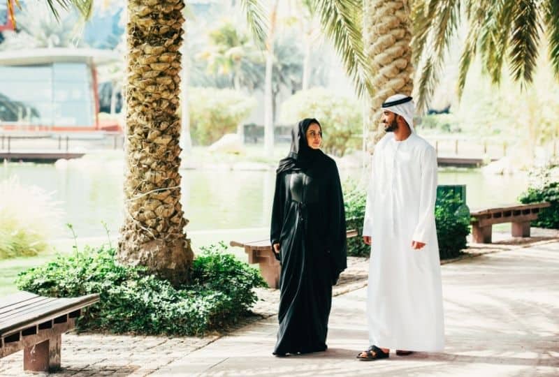 Emirati man and woman walking in the UAE wearing traditional Emirati clothes