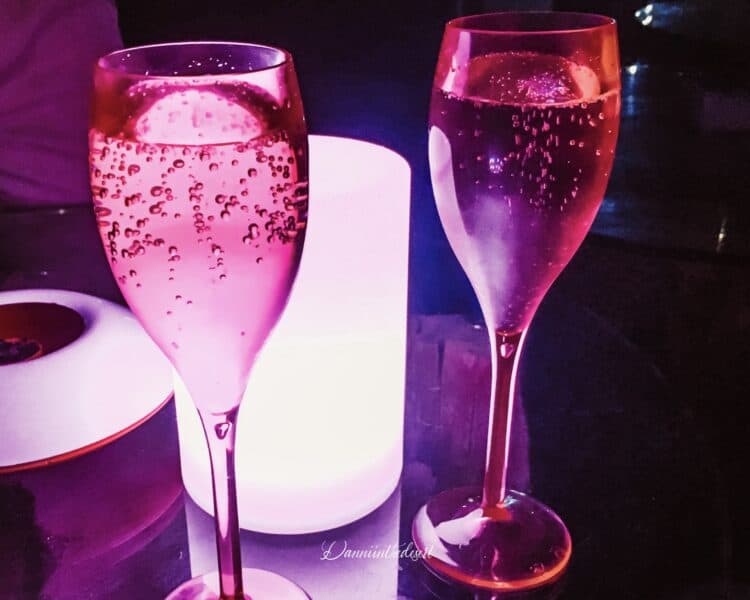 Two glasses of sparkling wine on a table with a lamp as part of Dubai's ladies nights at Jetty Lounge