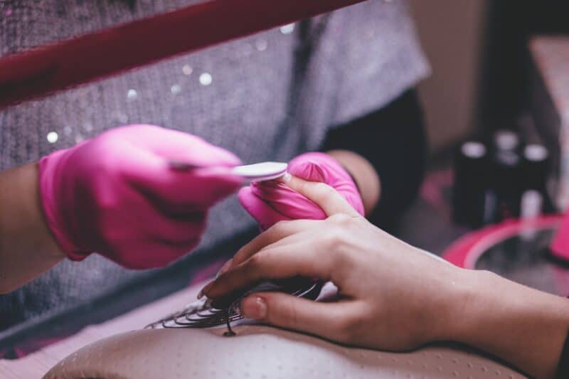 Women getting a manicure in a salon in Dubai with the nail technician filing her nail