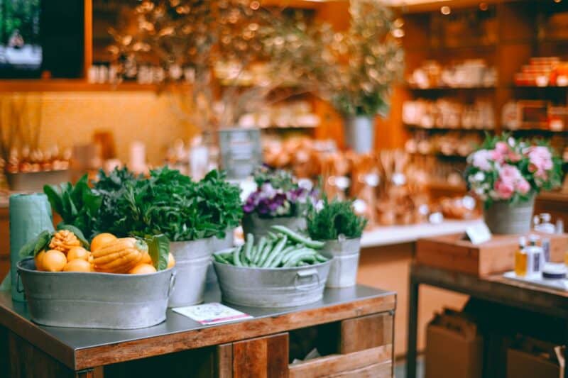 A grocery store with the vegetables placed nicely in buckets and organised on a table