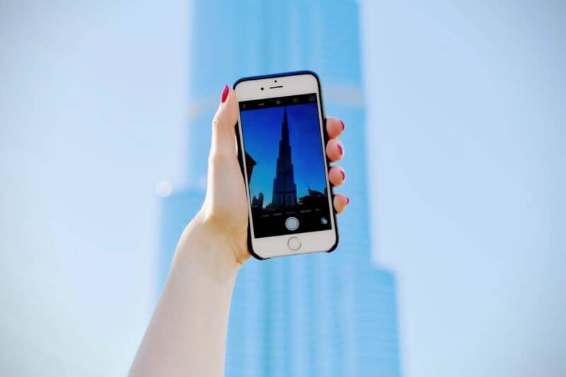 An iphone being held up against the Burj Khalifa