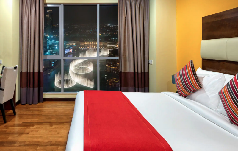 A double room with a view over Dubai Fountains lit up at night at Ramada Downtown Dubai