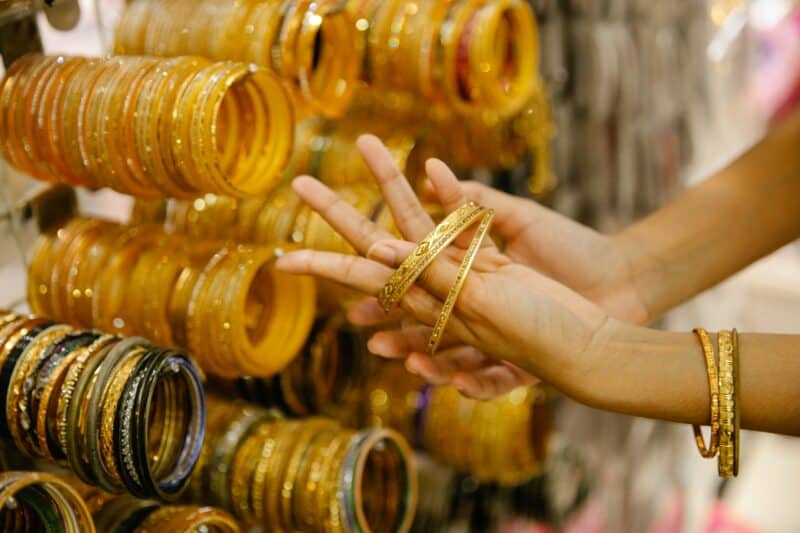 Buying gold in Dubai's gold souks and a woman trying on gold bangles