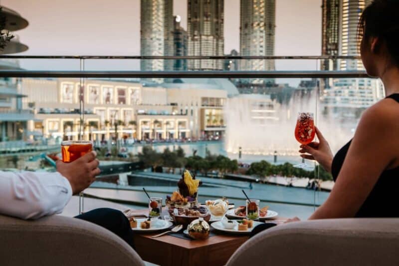 Couple enjoying a selection of food while watching the Dubai Fountain at dusk from the terrace at Armani Ristorante Dubai