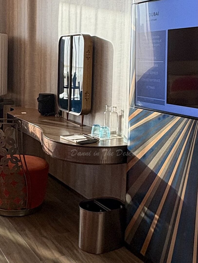 Two clear glass bottles with blue glasses on the vanity desk of a Dubai hotel called The W Mina 