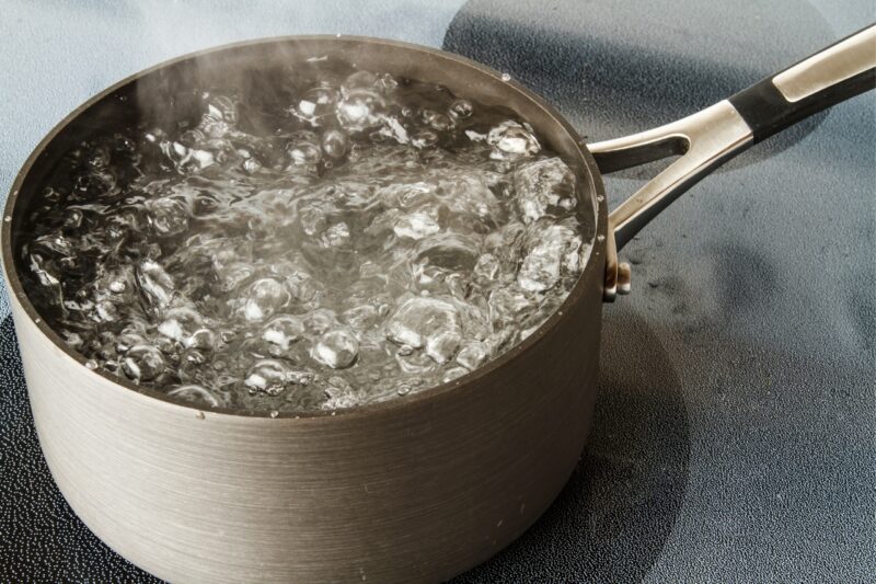 A boiling pot of water on a stove, freshly boiled. In a kitchen of a hotel apartment in Dubai.