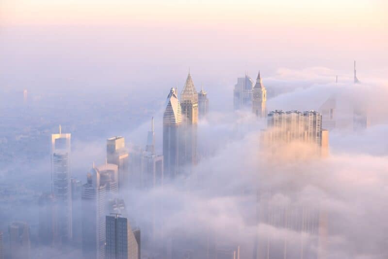 A foggy day in Dubai with the high rise buildings of Downtown Dubai and DIFC peaking out of the top of the clouds