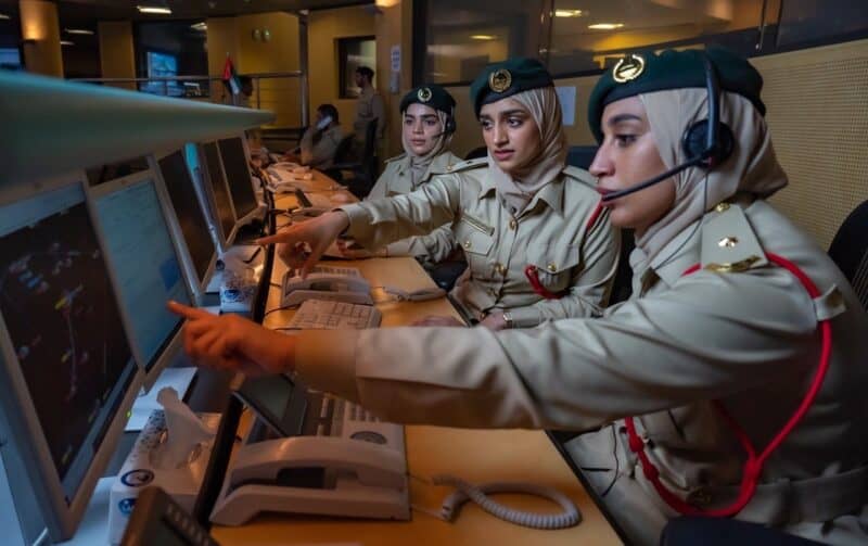 three dubai police women sat at a control panel