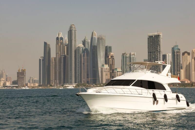 Private yacht tour sailing through the sea with Dubai Marina in the background