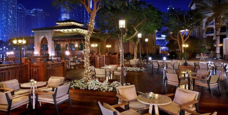 Nightime at the outdoor terrace of Buyhayra Lounge at Palace Hotel Downtown with views of Dubai Fountain and Burj Khalifa