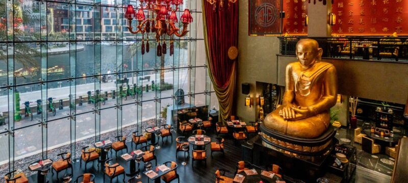 View from the second floor looking at the tables and huge gold buddha inside Buddha Bar at the Grosnevor Hotel in Dubai Marina