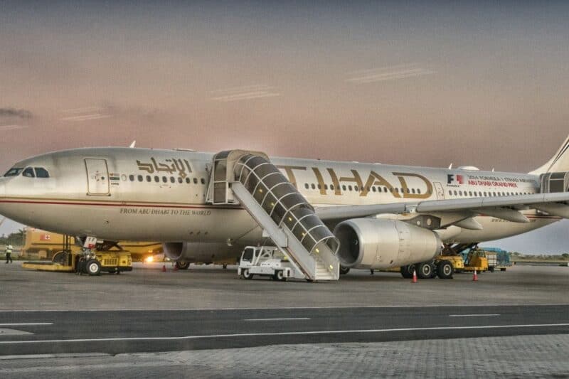 Etihad plane on the tarmac with a staircase attached