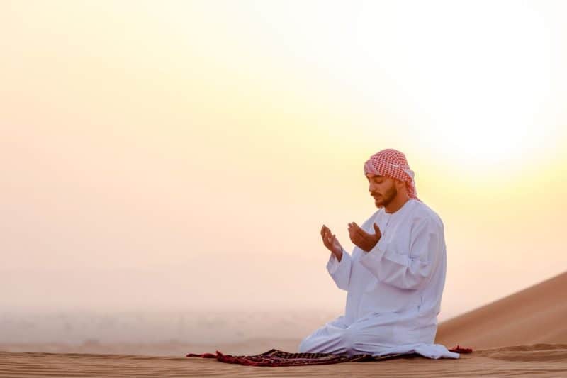 Emirati man praying in the desert where Islam is the main religion of Dubai