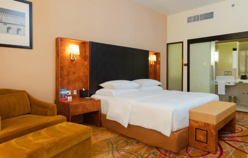 Photo of the inside of the now dated rooms at Millennium Airpot Hotel Dubai, large bed and sliding doors to the bathroom