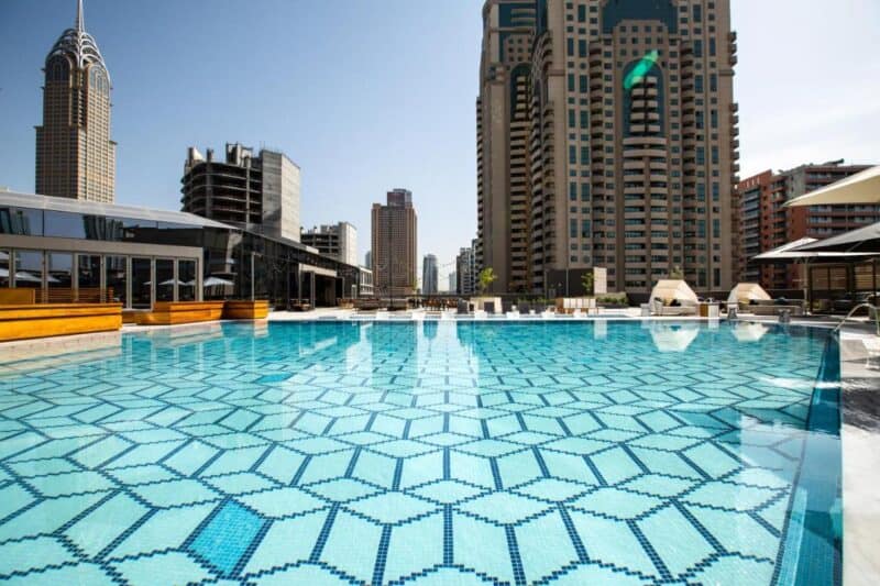 The beautiful large swimming pool with a nice mosaic pattern and view over central Dubai at Zabeel House by Jumeirah