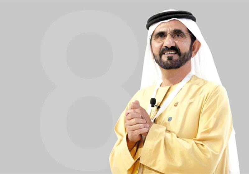 Photo of the Dubai Sheikh Mohammed Bin Rashid Al Maktoum standing holding his hands and wearing the traditional Emirati clothes