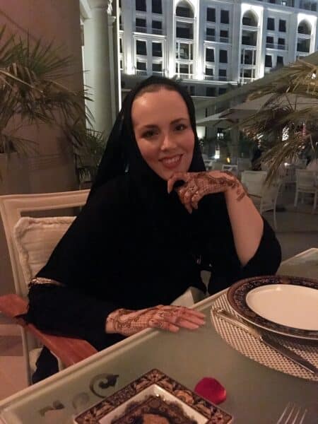 Photo of Danni B from Danni in The Desert sat at the table on the outdoor terrace Vanitas restaurant, Versace Hotel Dubai during a romantic meal with the hotel in the background