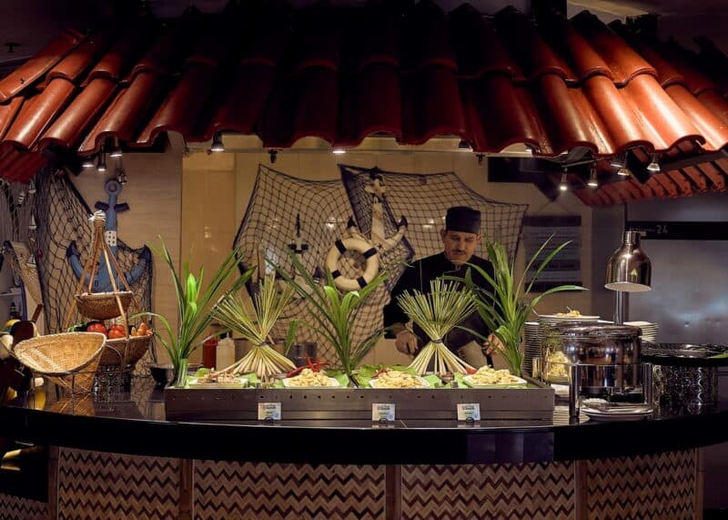 A chef preparing dishes live with a selection at the front at Spice Island in Dubai