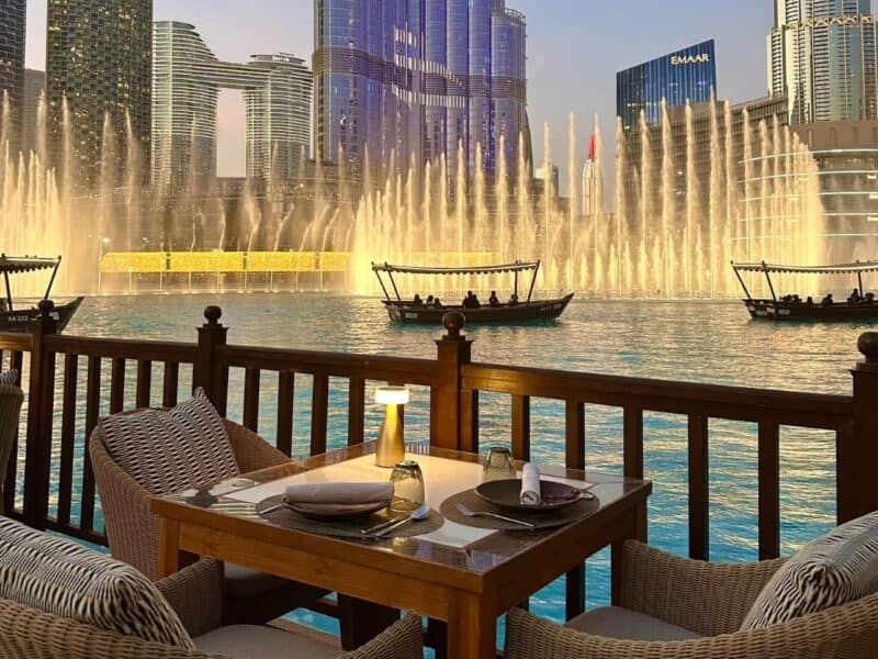 A table set up outside and ready for diners at Thiptara with Dubai Fountain going off and abra boats floating across the water