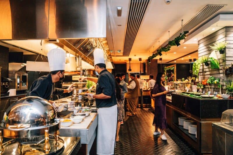 Chefs working on the buffet options while diners walk around the restaurant and select the foods they want inside Yalumba in Dubai