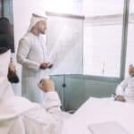 Men in local dress taking part in a meeting at work