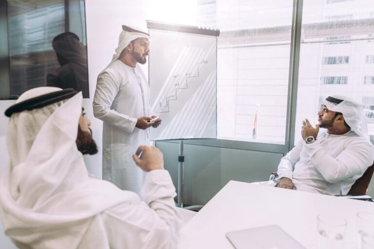 Men in local dress taking part in a meeting at work