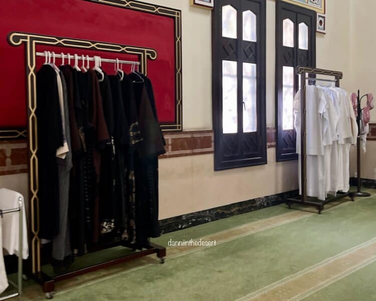 Women's abayas on the left and Emirati khadoras with shamaghs on the right inside the prayer hall of Jumeirah Mosque ready for visitors to wear