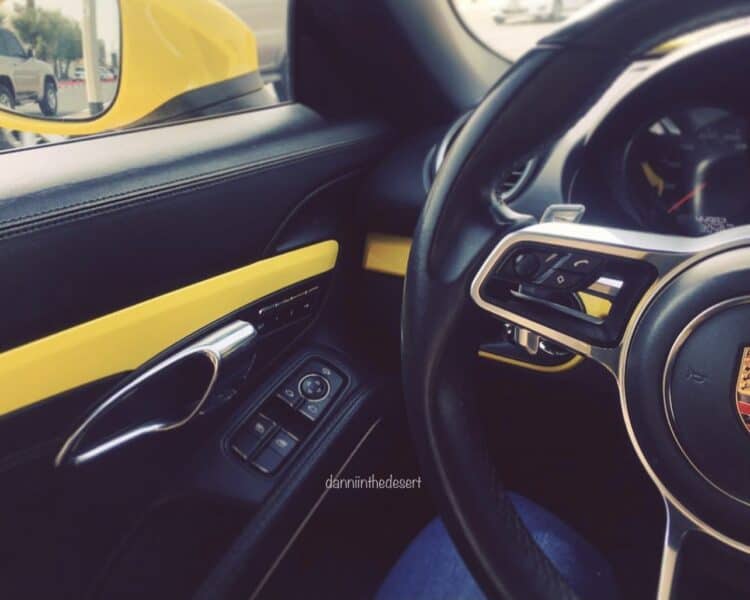 The inside of a Porsche Boxster sport being driven in Dubai