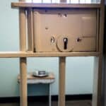 The inside of a jail cell with a light brown colour painted lock