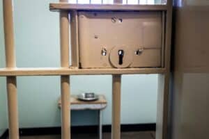 The inside of a jail cell with a light brown colour painted lock