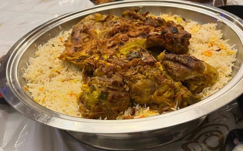 Meat mandi served on a traditional metal plate with a plastic mat and raised off the floor with a metal stand at Rayyan Mandi