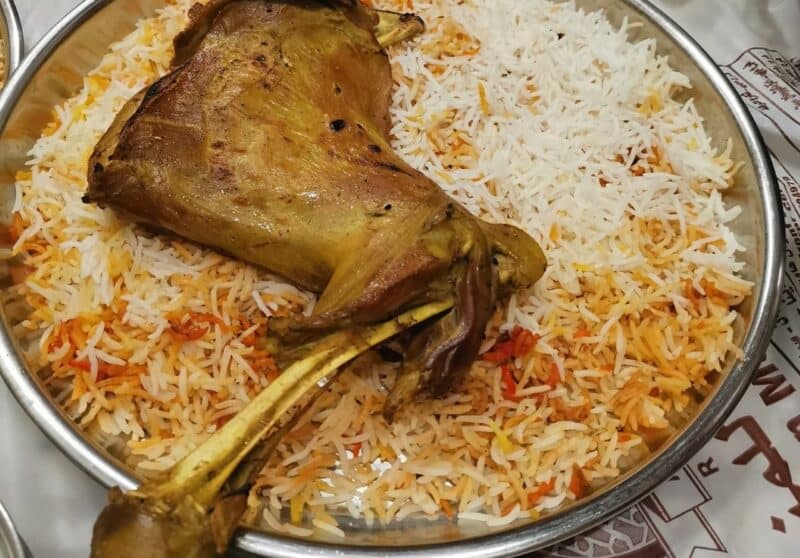 A large meat mandi served on the bone with a plate of basmati style rice