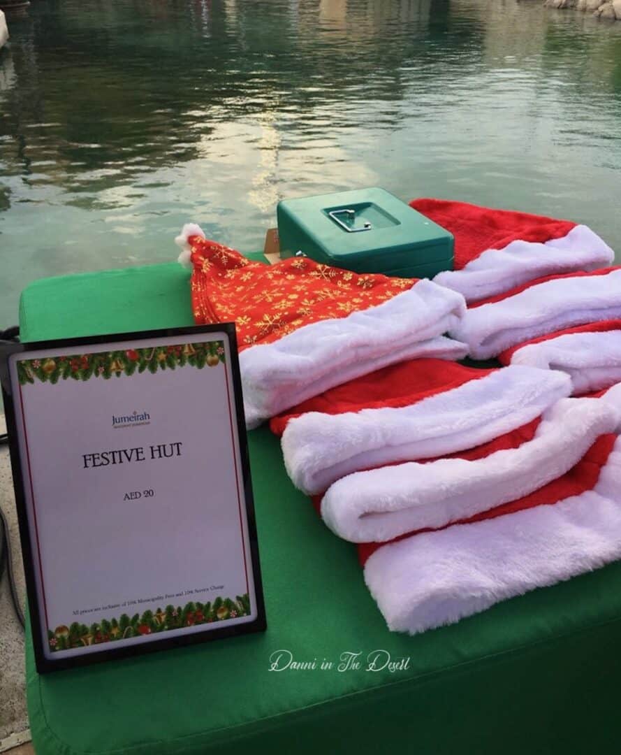 Christmas hats for sale, places on a table with a sign at Madinat Jumeirah for those wanting to get in the Christmas spirit