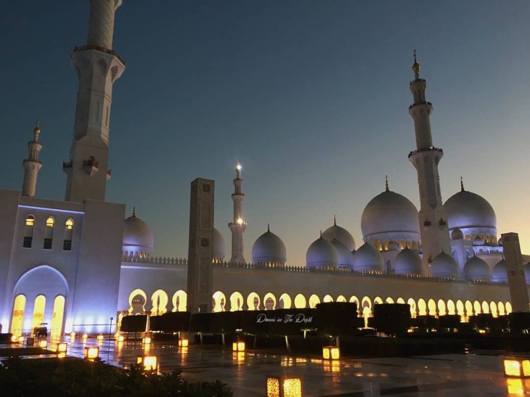 Sheikh Zayed Mosque with its domes gently lit up, viewing from the courtyard at the front during dusk at the last sunlight disappears