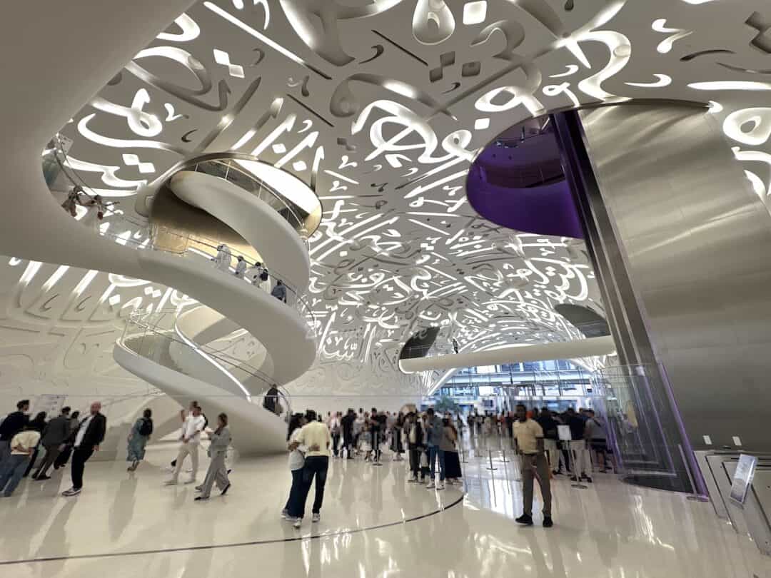 Interior of the Museum of the Future, the iconic lobby with the Arabic calligraphy ceiling and people queueing to visit