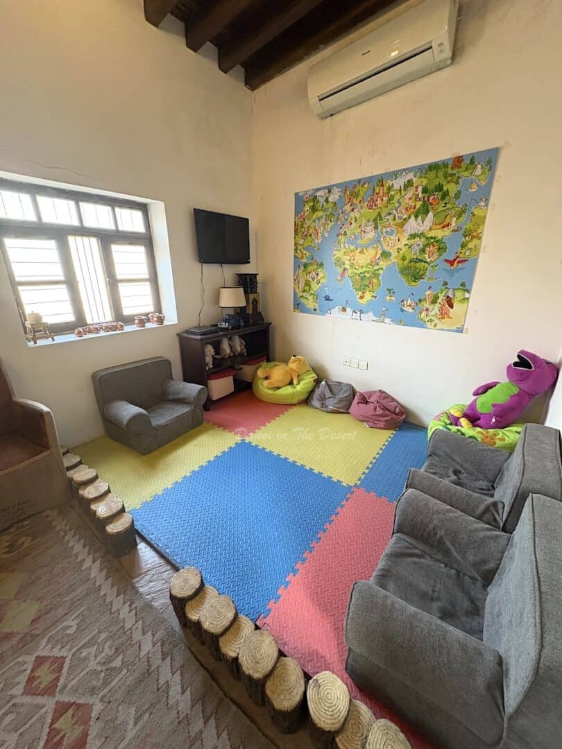 A colourful children's area with several chairs and child proof flooring plus a few cuddly toys dotted around the room inside Dubai's coffee museum