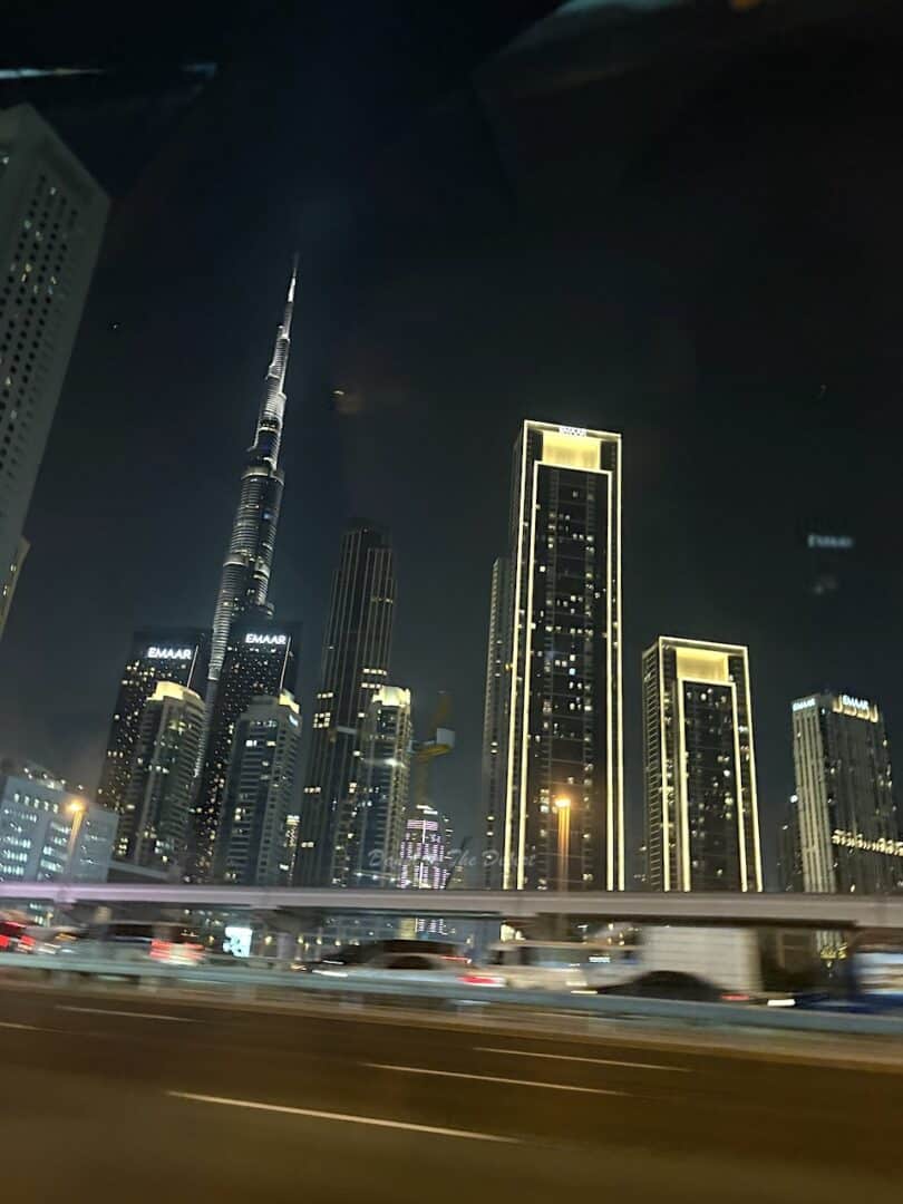 Burj Khalifa and Downtown Dubai skyline lit up at night as viewed from Sheikh Zayed Road